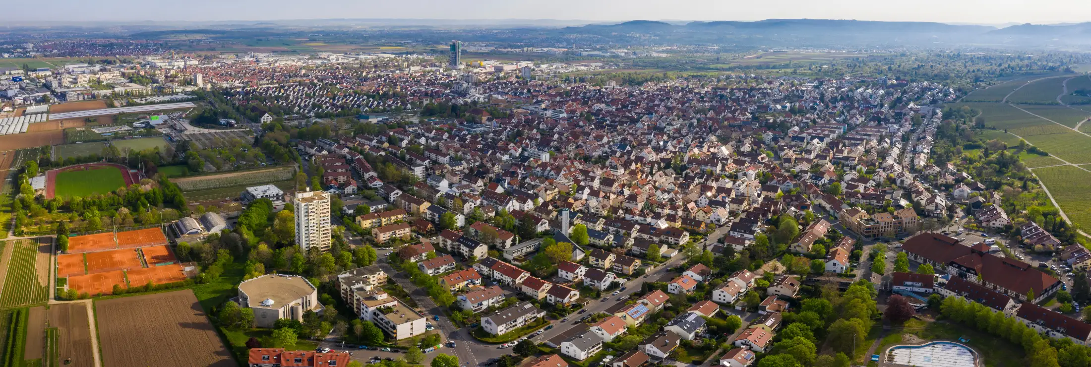 Luftaufnahme Fellbach: links Tennisplätze TEV Rot-Weiß Fellbach, Max Graser Stadion, Neuapostolische Kirche; daneben Immobilien Esslinger Str. / Eugenstr., rechts Altes Freibad, Alte Kelter Fellbach; dahinter links Schmiden, mittig Fellbach Kernstadt