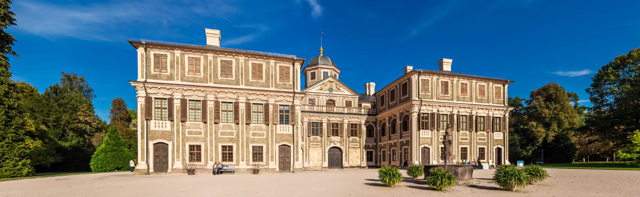 Aufnahme von Schloss Favorite Rastatt im Stadtteil Niederbühl von Westen bzw. von der Hofseite an einem Sommertag. Zu sehen ist ein barockes Lustschloss mit dem von den Seitenflügeln umschlossenen Ehrenhof