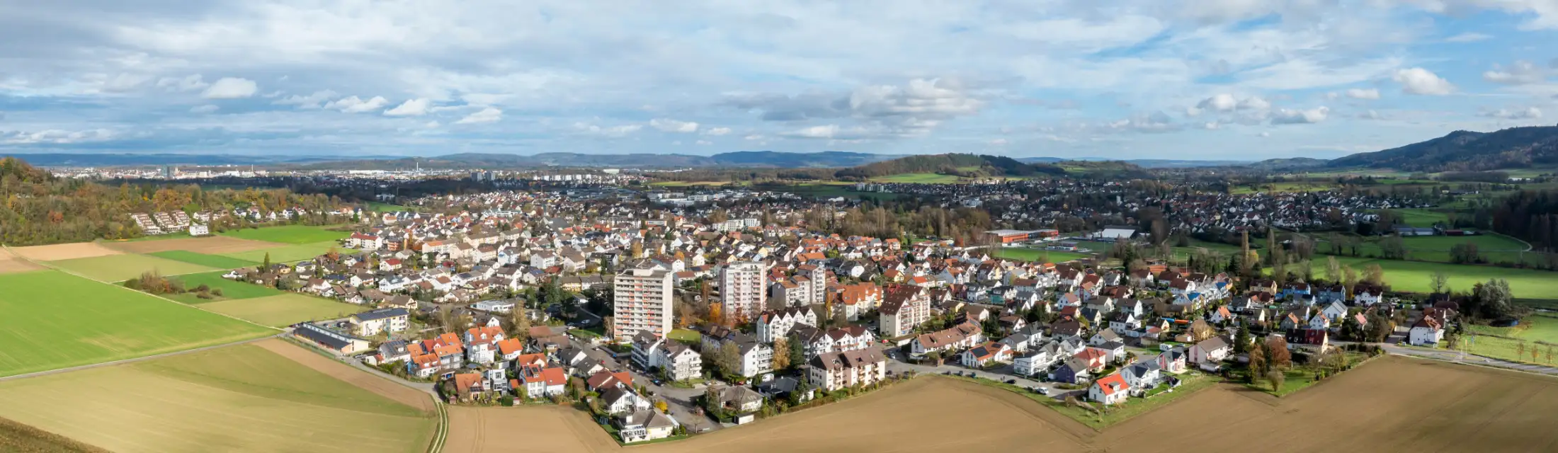 Luftaufnahme von Rielasingen-Worblingen, Blick von Westen, Talweg. Vorne Hochhäuser Grenzstraße (25 und 27) und Sportplatz Talwiese, dahinter mittig Immobilien östliches Rielasingen-Worblingen, links der Norden und rechts der Süden der Gemeinde.