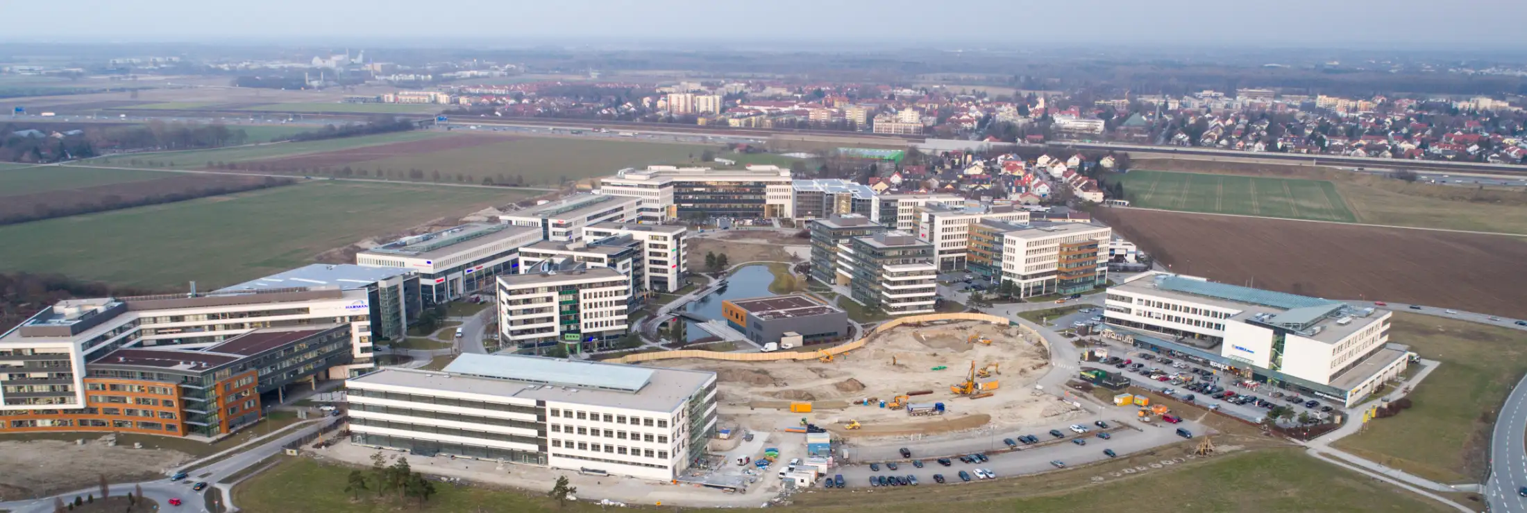 Luftaufnahme von Garching bei München, Blickrichtung Osten: vorne Immobilien Parkring, dahinter Wohnhäuser zwischen Schleißheimer Straße, Hardtweg und Heideweg, dahinter (von links nach rechts) Autobahn A 9, dahinter der Hauptort Garching bei München.