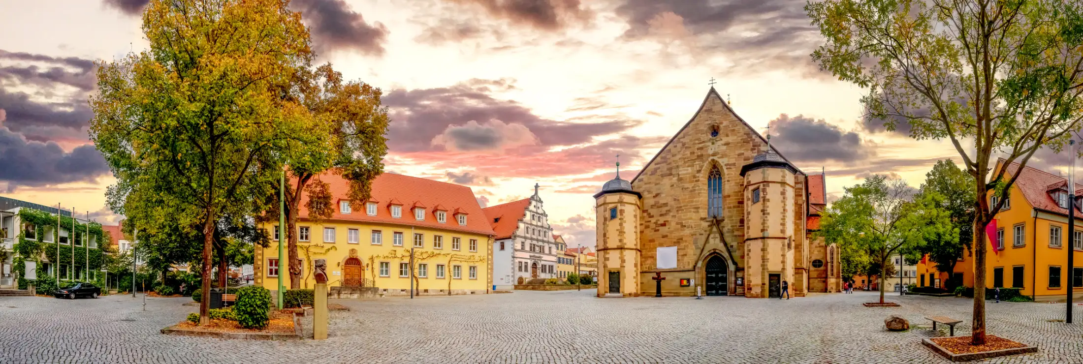 Panoramaaufnahme Innere Altstadt Schweinfurt, Martin-Luther-Platz: links Stadtarchiv, daneben Evangelisch-Lutherisches Dekanat Schweinfurt, davor Denkmal Martin Luther, rechts St. Johanniskirche, ganz rechts Immobilien südlicher Martin-Luther-Platz.