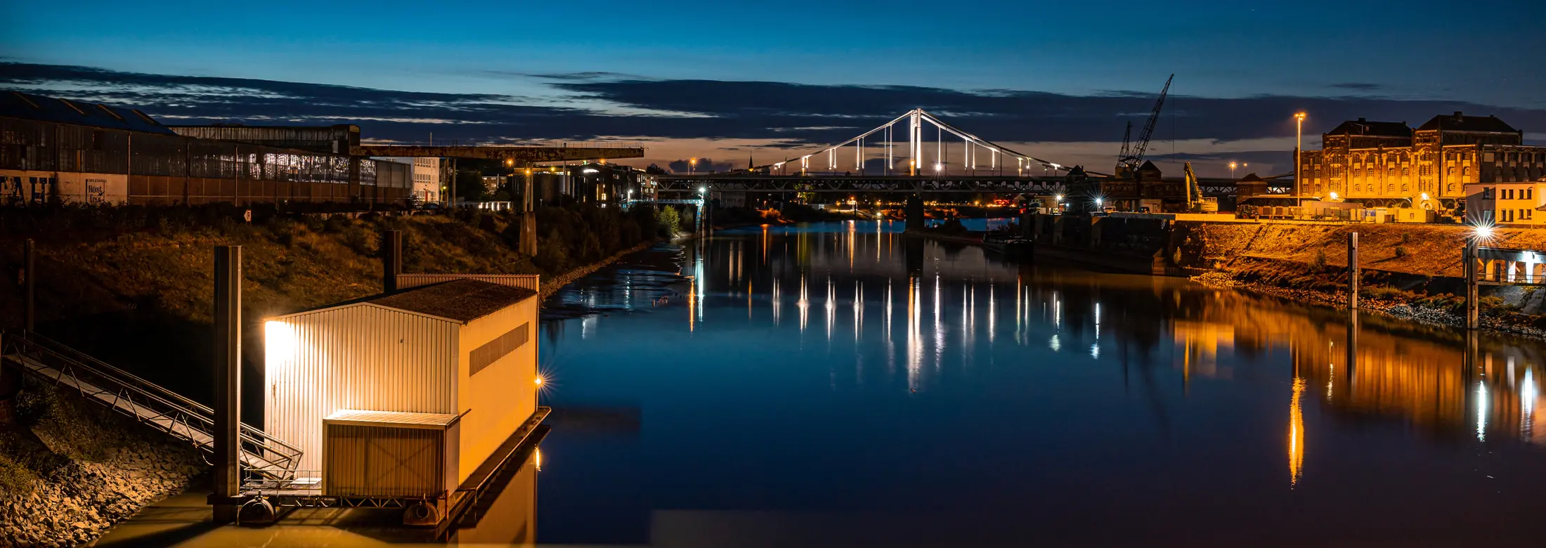 Der Hafen im Südosten von Krefeld in Gellep-Stratum und Linn bei Nacht, im Hintergrund die Rheinbrücke nach Krefeld Uerdingen