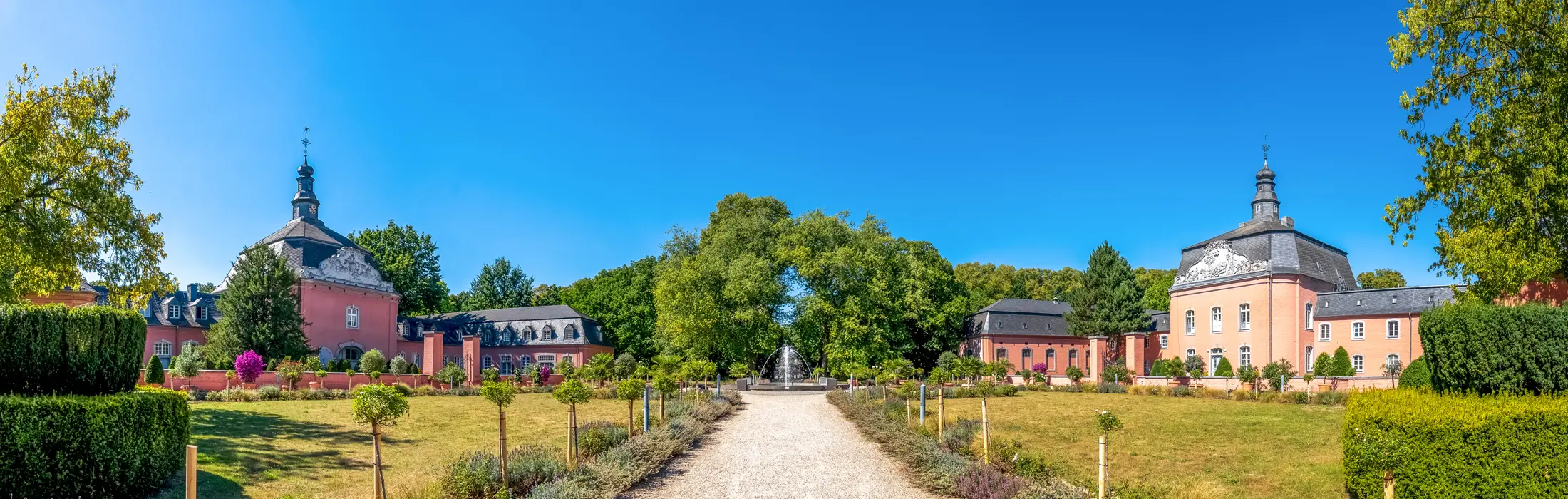 Schloss Wickrath in Mönchengladbach-Wickrath mit Westflügel und Ostflügel der Vorburg und Schlosspark an einem Sommertag