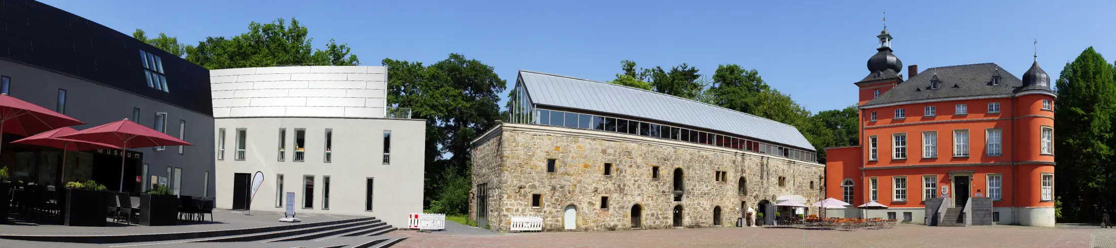 Panoramaaufnahme Burg Wissem in Troisdorf: links das Museum für Stadt und Industriegeschichte Troisdorf, mittig die Remise, rechts das Herrenhaus mit dem Bilderbuchmuseum