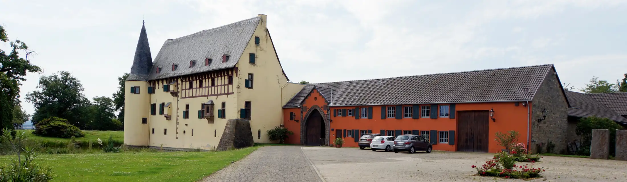 Die Burg Langendorf, eine Wasserburg in Zülpich, von Norden: links das Herrenhaus, davor der Wassergraben, rechts die Vorburg