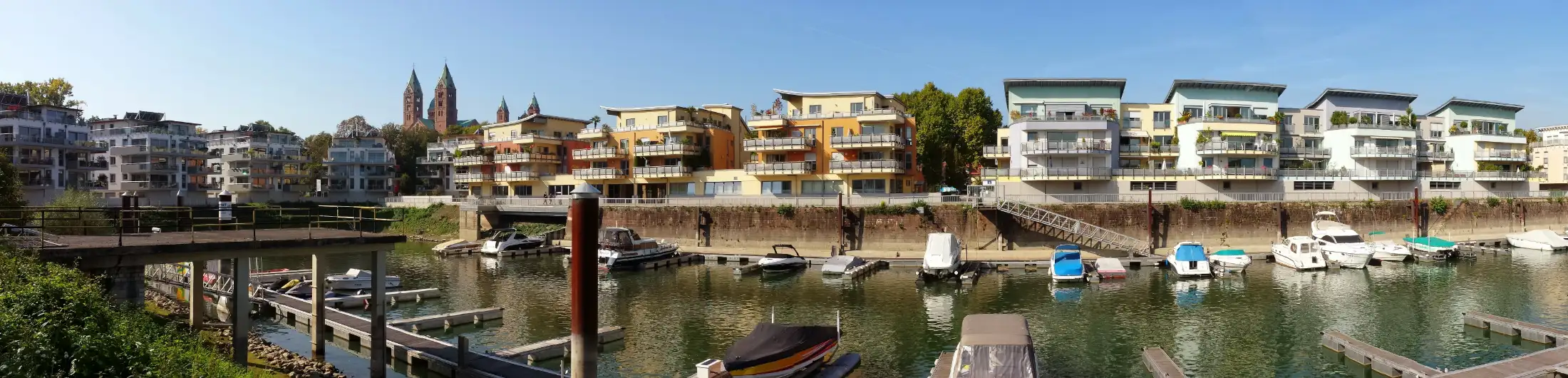 Panoramaaufnahme Yachthafen Speyer: Vordergrund Hafen Speyer mit Booten, dahinter exklusive Wohnhäuser, links Immobilien Am Hafenbecken, daneben der Dom zu Speyer, daneben Immobilien Hafenstraße