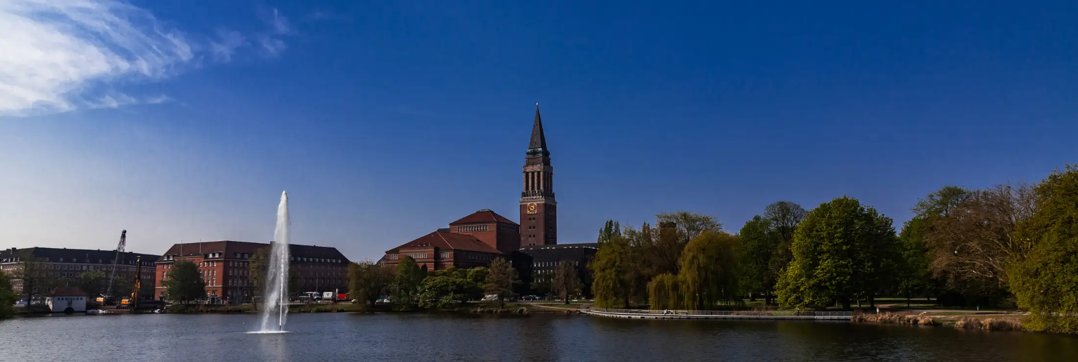 Blick über Kleiner Kiel von Norden. Links die Immobilien südlich am Kleiner Kiel, die sich an Holstenbrücke und Rathausplatz befinden, daneben vorne das Opernhaus, dahinter verdeckt das Rathaus, mit sichtbarem Rathausturm, rechts der Hiroshimapark.